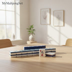 American mahjong tiles in grey and white acrylic arranged on a wooden table in a bright, modern room