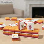 MyMahjongSet acrylic mahjong tiles with colorful layered design, featuring hummingbird and vase motifs on a wooden table