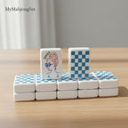 Blue gingham American mahjong tiles featuring a stylized Joker tile on a wooden table
