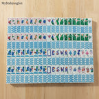 Blue gingham American mahjong tile set featuring colorful summer vacation icons and checkered tile backs