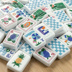 Blue gingham American mahjong tiles with colorful summer-themed travel illustrations