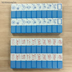 Stacked blue vertical stripe acrylic American mahjong tiles showing the striped tile backs and patterned faces