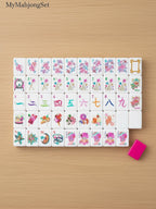 MyMahjongSet modern magenta candy pattern acrylic American mahjong tiles with colorful illustrations on a wooden table.