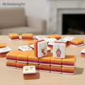 American mahjong tiles set with a sunset hummingbird design, arranged on a wooden table