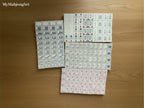MyMahjongSet 160-piece American mahjong tile set in white pearl acrylic with detailed engraved symbols on a wood table.