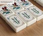 American mahjong tiles arranged in a row, showing the elegant ivory acrylic finish and detailed tile designs