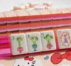 Pink Diamond American Mahjong tiles displayed on a translucent pink acrylic rack, featuring glossy acrylic tiles with elegant bamboo designs in a vibrant pink gradient colorway, perfect for American Mahjong enthusiasts.