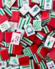 Red American Mahjong tiles with a glossy acrylic finish featuring a vibrant red, white, and green colorway. Close-up of premium Mahjong tiles showcasing floral, bamboo, character, and Joker designs, ideal for American Mahjong players, collectors, and game night enthusiasts.
