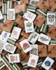 Scattered wood grain American Mahjong tiles with premium acrylic construction, featuring elegant natural wood grain backs and classic American Mahjong symbols for a stylish game set.
